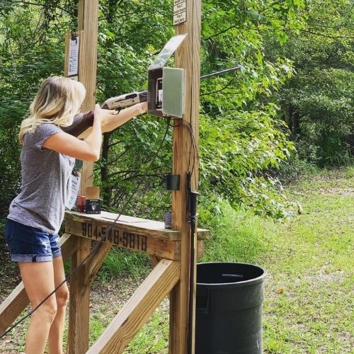 Woman shooting a shotgun at Amelia Shotgun Sports Sporting Clay station
